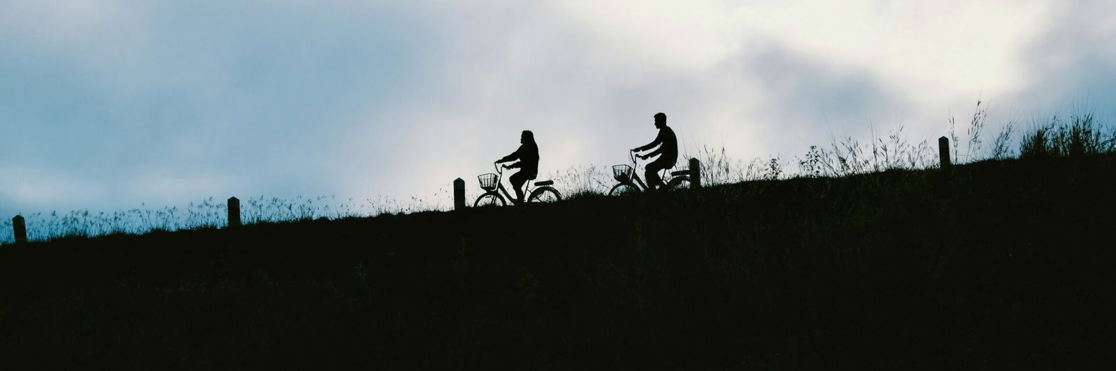 2 people riding bikes down hill
