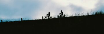 2 people riding bikes down hill