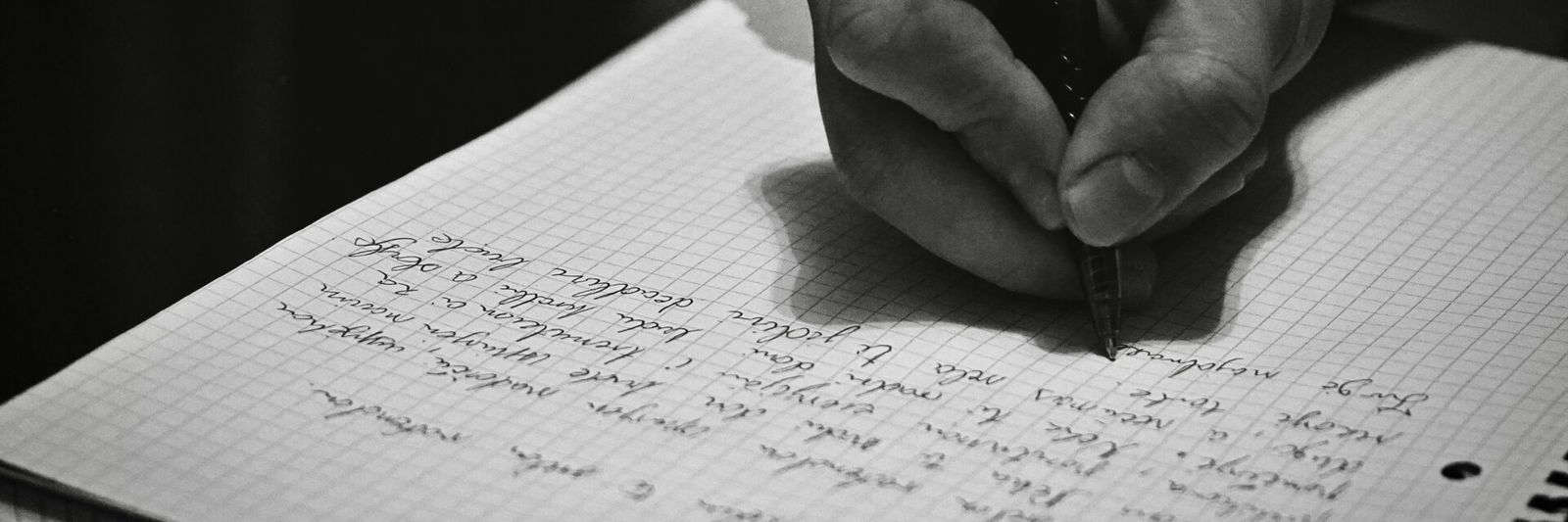 Person writing message notebook